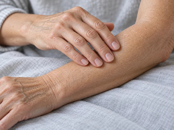 Fingertips gently smoothing a dry forearm